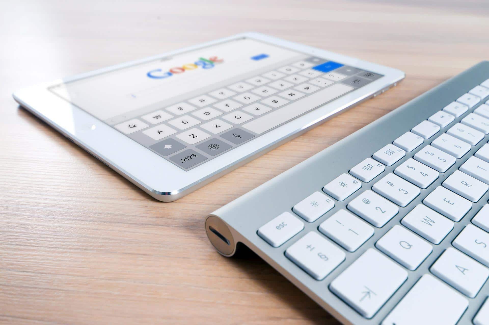 Tablette affichant la page d'accueil de Google à côté d'un clavier sans fil